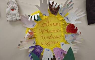 Na ż&oacute;łtym tle dekoracyjny napis Centrum Opiekuńczo mieszkalne