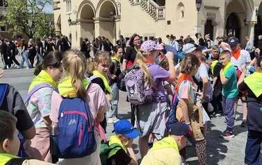 Duża grupa uczni&oacute;w przed Sukiennicami w Krakowie