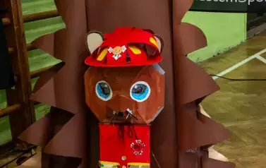 Jeż strażak w czerwonym kasku na głowie i w czerwonej kamizelce