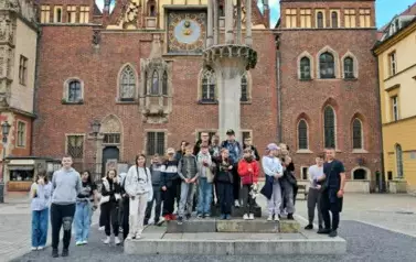 Duża grupa dzieci podczas wyjazdu Eroweek we Wrocławiu, stojąca przed Ratuszem.