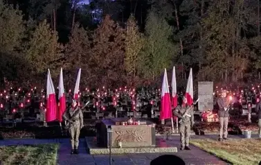 Apel poległych z udziałem żołnierzy i harcerzy na cmentarzu w lesie w Puszczy Kampinowskiej - Palmirach. Grupy żołnierzy na warcie przed mogilami poledłych.