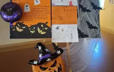 Na Sojaku plakty z opisem halloween. Na dole syojaka dmuchana dynia w czarnym kapeluszu