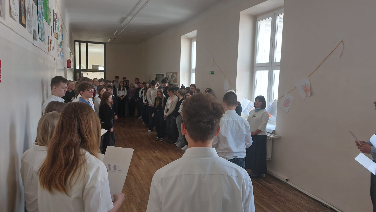 Duża grupa uczni&oacute;w w&nbsp;galowych strojach podczas apelu z&nbsp;okazji święta Konstytucji 3 maja