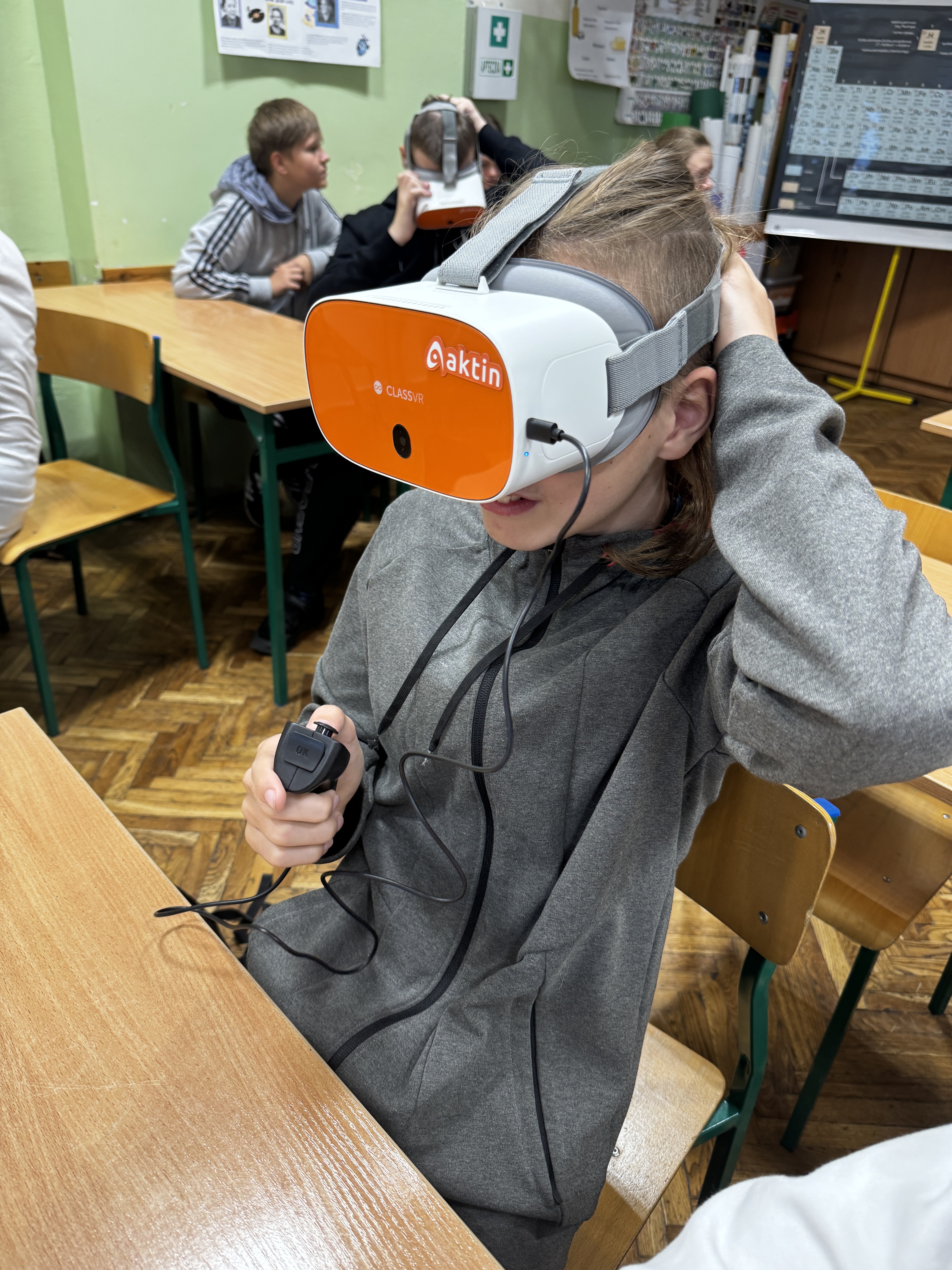Uczeń siedzi w&nbsp;ławce szkolnej w&nbsp;goglach VR