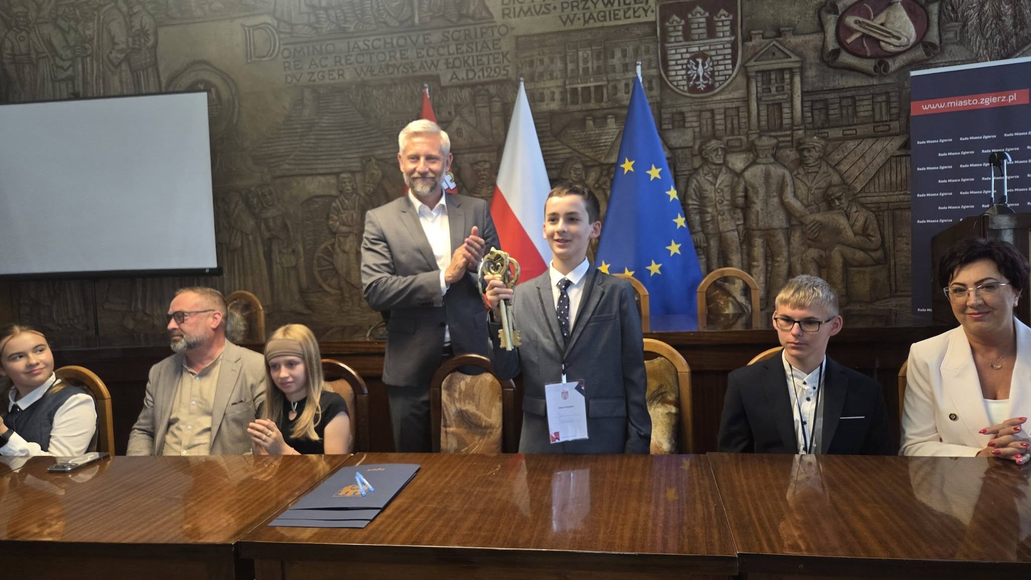 Wlodarze miasta Zzgierza przy stole obrad w&nbsp;sali UMZ Zgierza wraz z&nbsp;uczniami z&nbsp;okazji Dnia Dziecka, w&nbsp;kt&oacute;rej uczniowie pełnią ich role