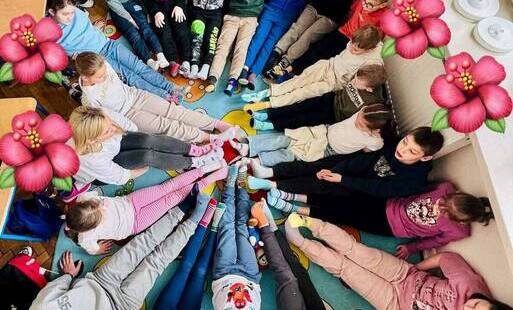 W kole nogi dzieci w kolorowych skarpetkach, z okazji obchodów Światowego Dnia Zespołu Downa