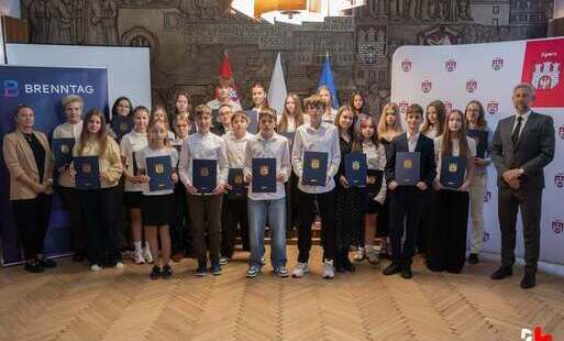 Duża grupa uczniów pozuje do zdjęcia w UMZ z prezydentem miasta i przedstawicielką firmy Brenntag, po odebraniu stypendium dla uczniów zdolnych